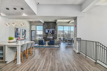 a view of the lobby of a building with tables and chairs and a kitchen and